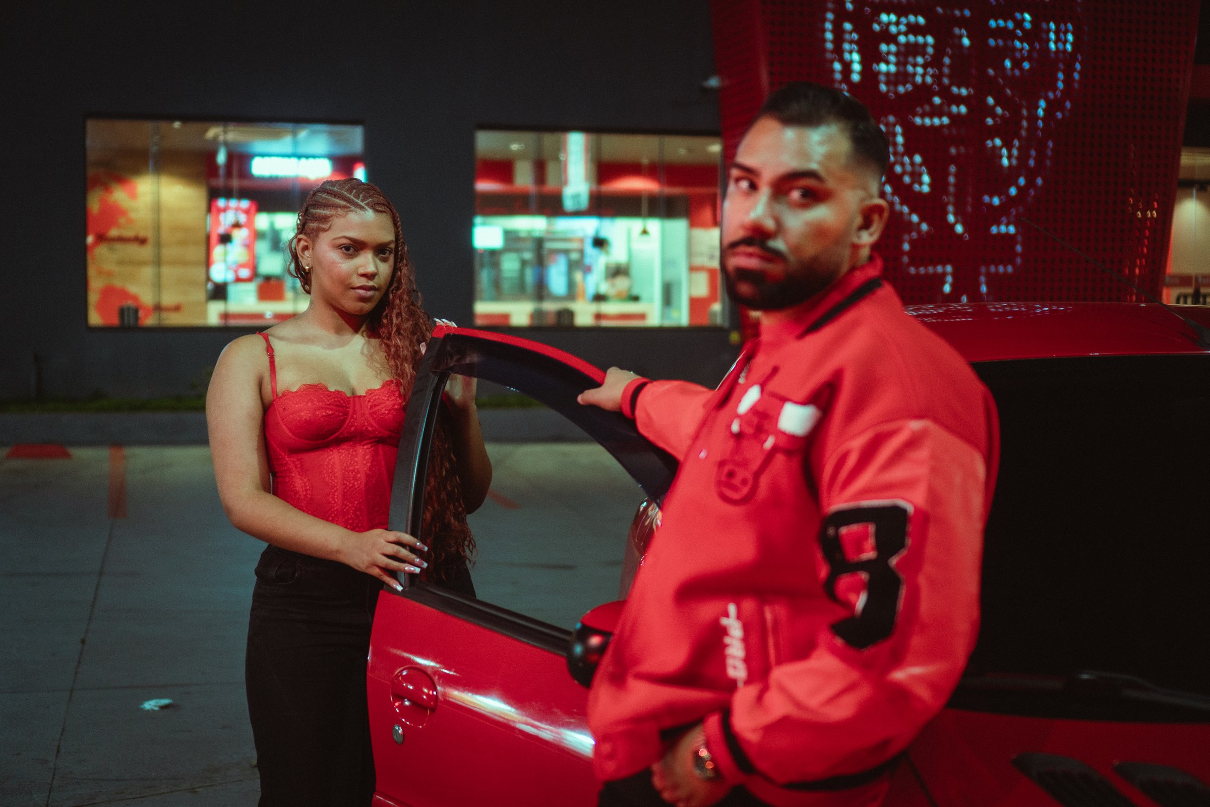 Modelo ao lado do carro vermelho e Jay Hoo em primeiro plano
